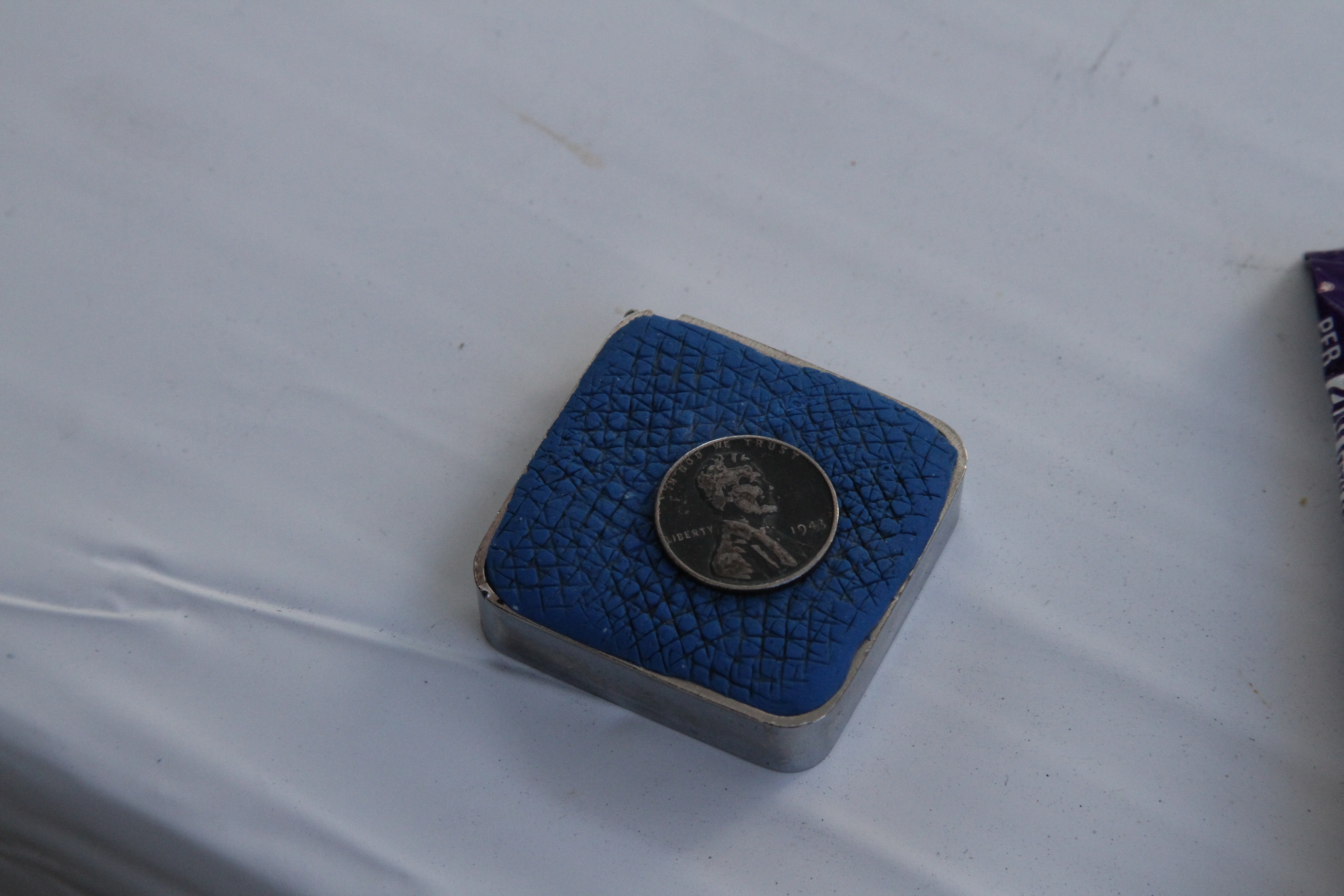 Steel penny on magnet on measuring tape