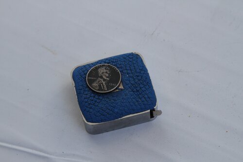 Steel penny on magnet on measuring tape